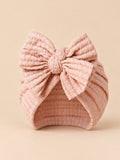 Bonnet turban bébé fille en coton tricoté rose poudré, nœud, vue de face
