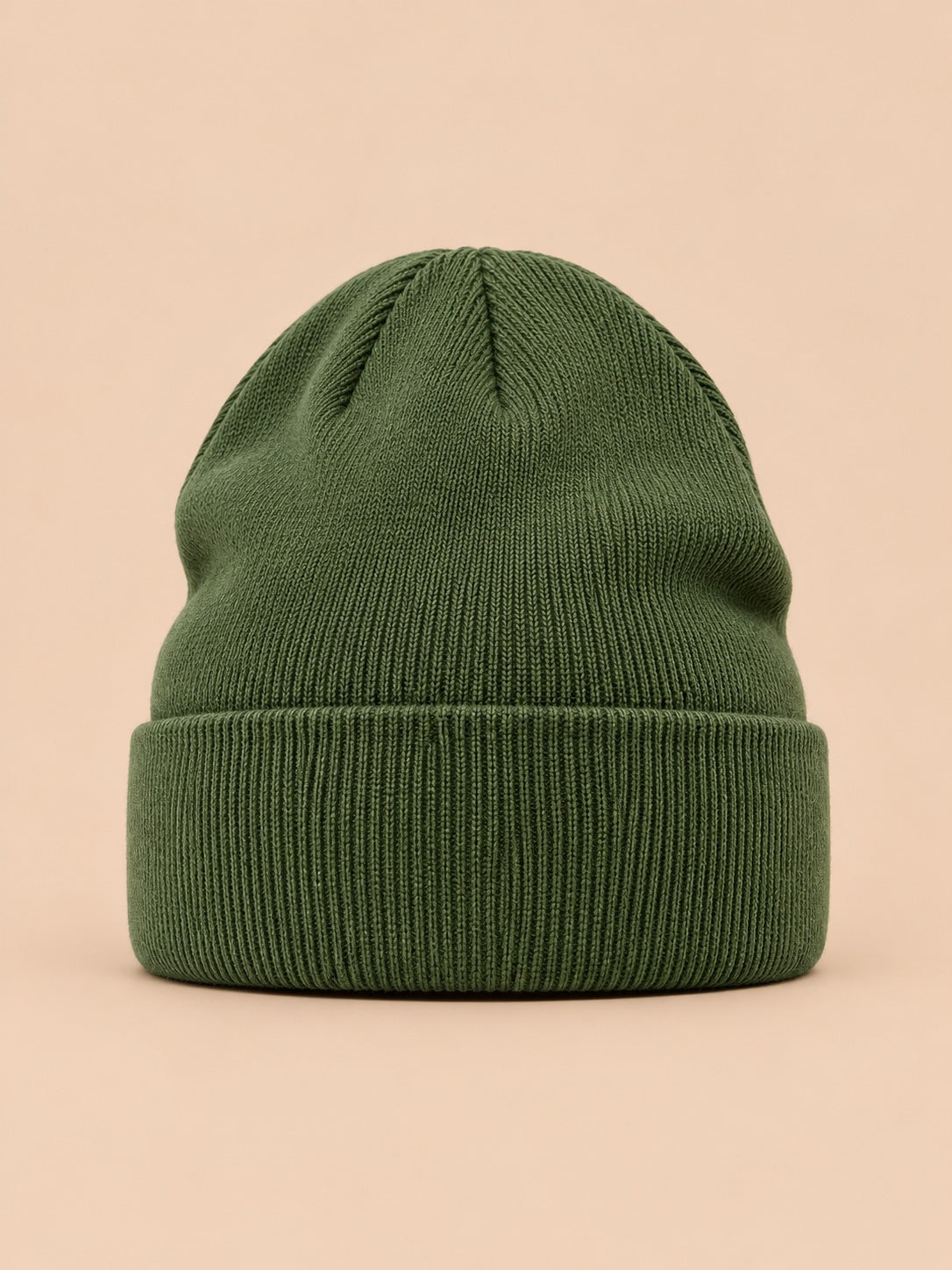 Bonnet uni classique en maille vert, vue de face sur fond pêche sable